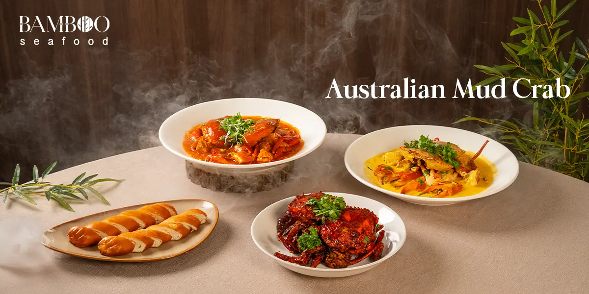 bamboo seafood menu page which has 3 australian mud crab dishes which includes chilli crab, black pepper crab, and salted egg crab with a side of mantou. All layed down on a table with a wooden background with hot smoke surrounding the dishes